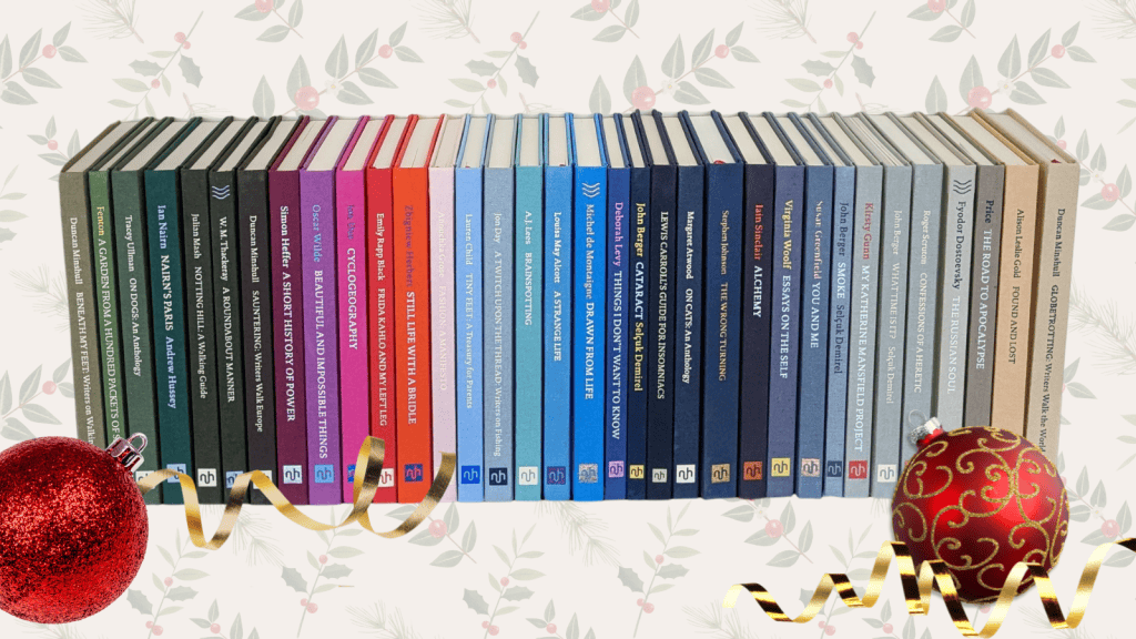 A stack of NHE books on a festive background, and a couple of baubles and gold ribbons in the foreground